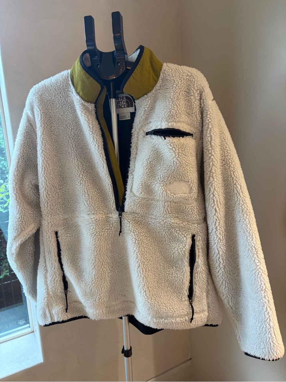 The North Face men’s Cream Sherpa Pullover with Olive Trim